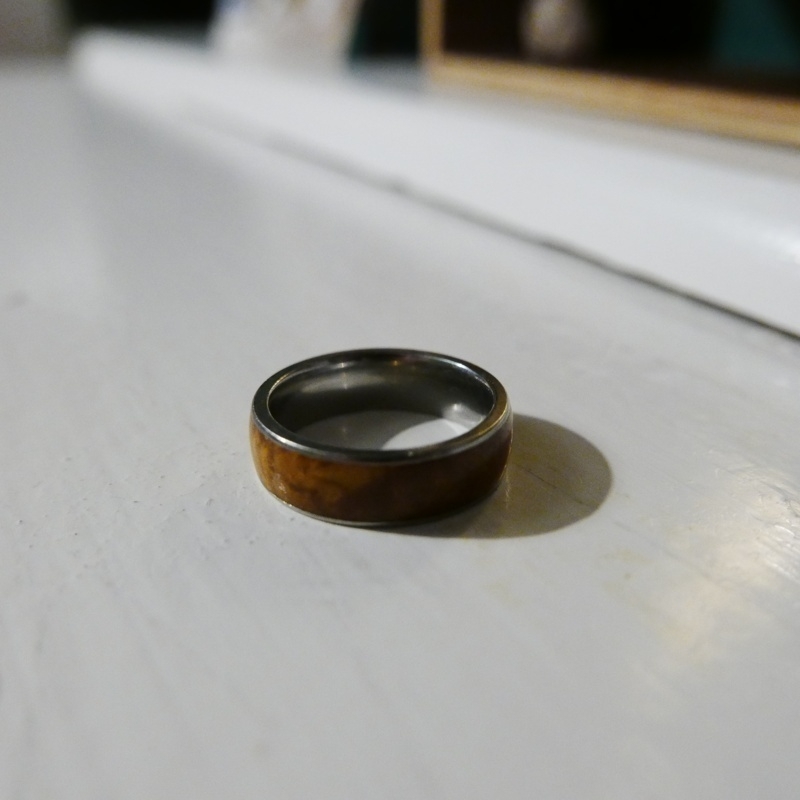 A photo of a silver-coloured wedding band with wood inlaid